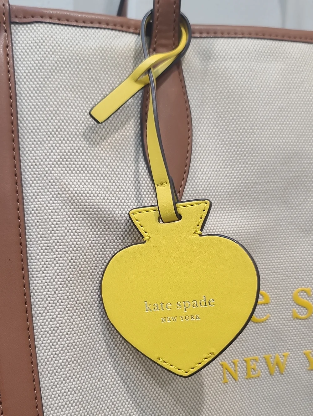 kate spade Beige Canvas Tote with Brown Trim and Yellow Charm